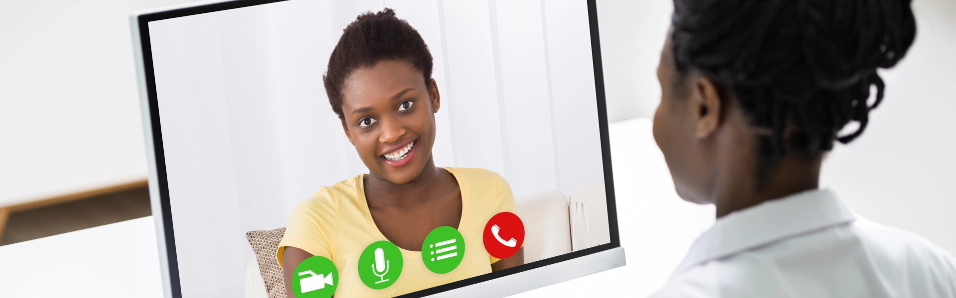 a woman talking and smiling to a female doctor through video call